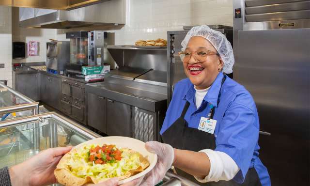 Smiling employee working in the hospital cafeteria