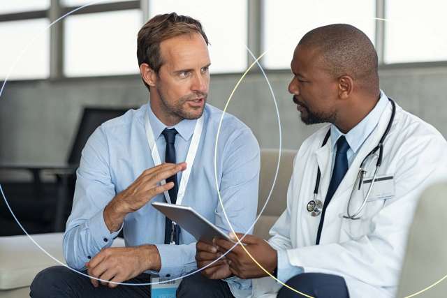 Businessman and doctor holding a tablet discussing.