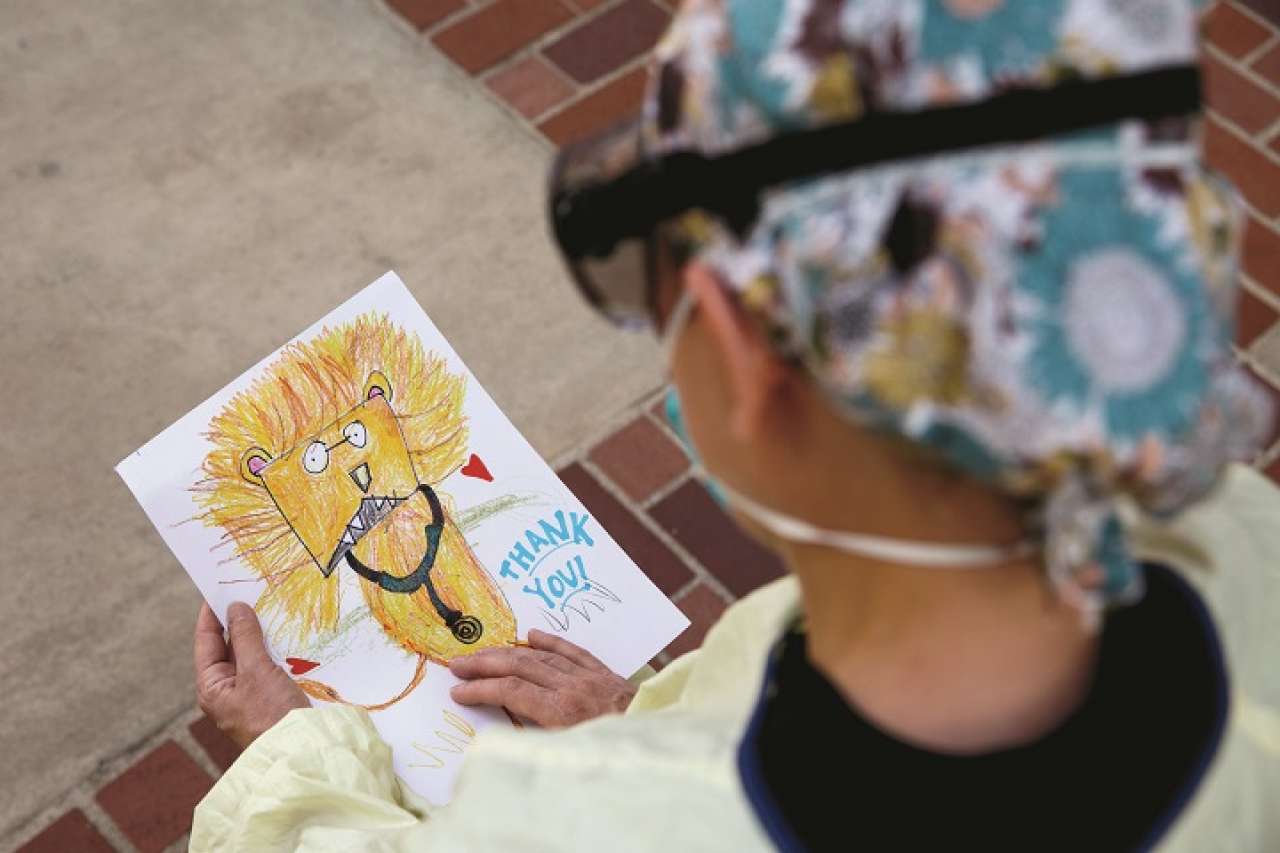 Physician holding Thank You card